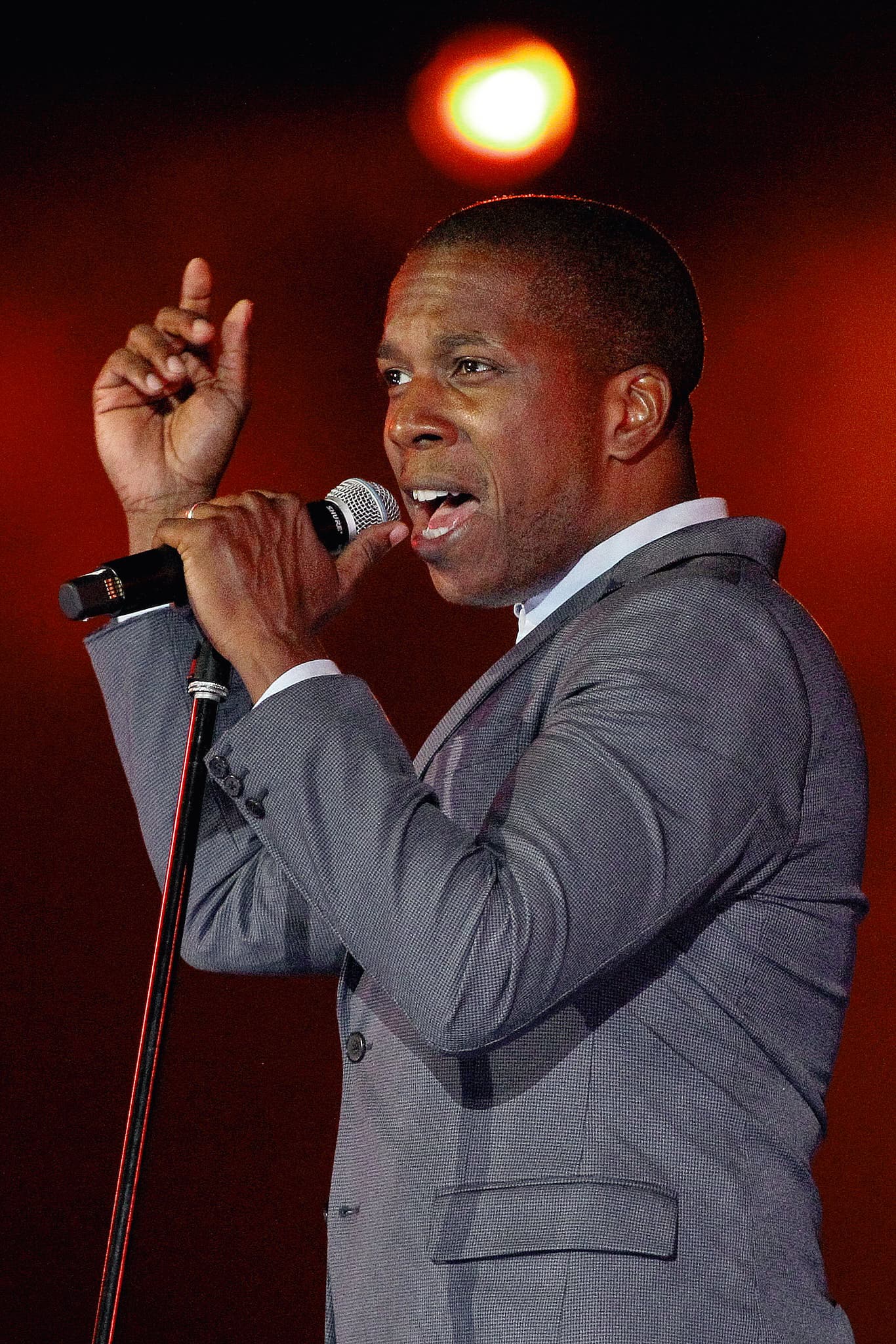 Professional concert photography of Tony Award-winning artist Leslie Odom Jr. performing on stage. Theater and music performance documentation demonstrating expertise in stage lighting and performance capture.