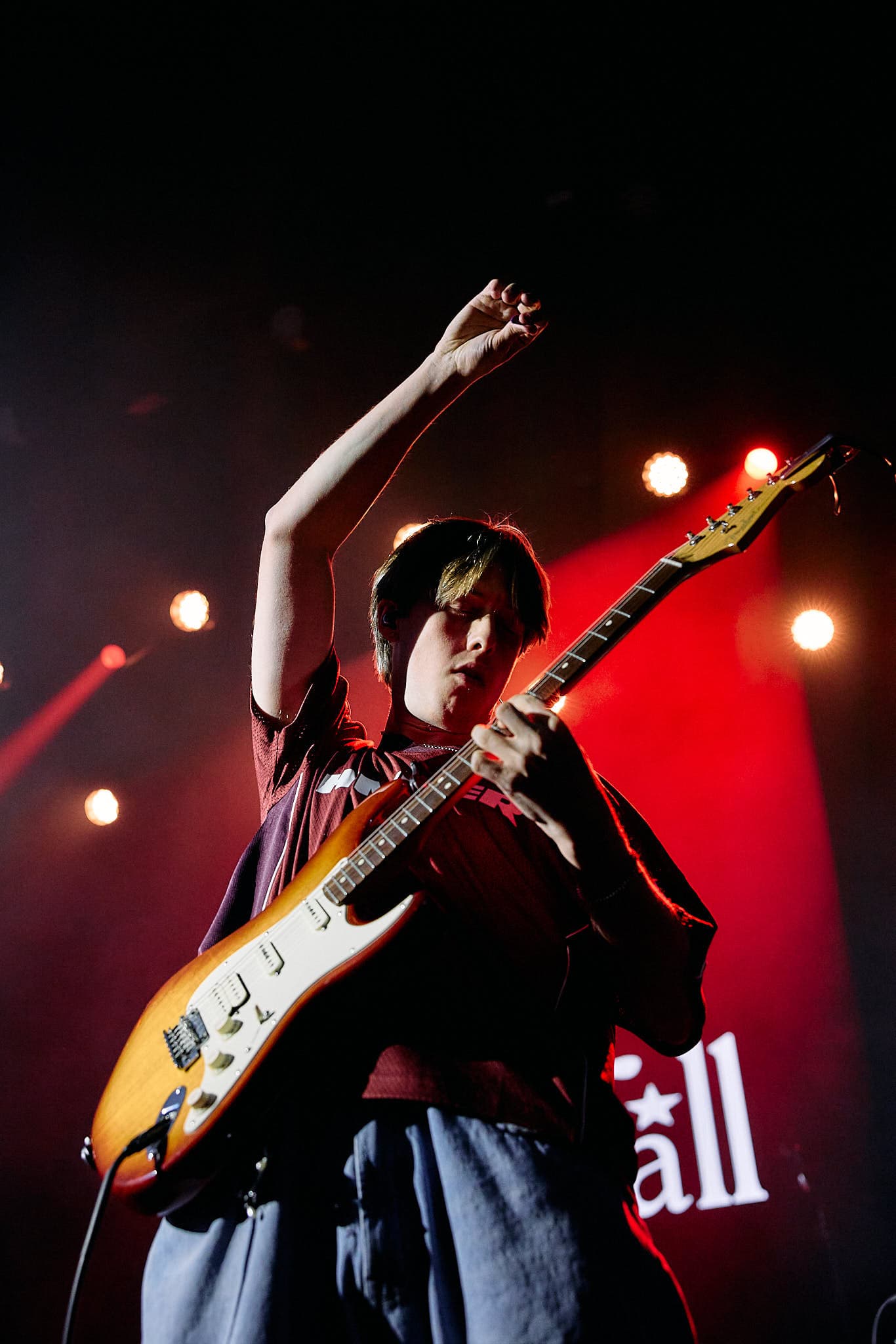 Concert photography of the guitarist for electronic music artist Starfall performing. Stage performance with professional lighting capture and electronic music production documentation.