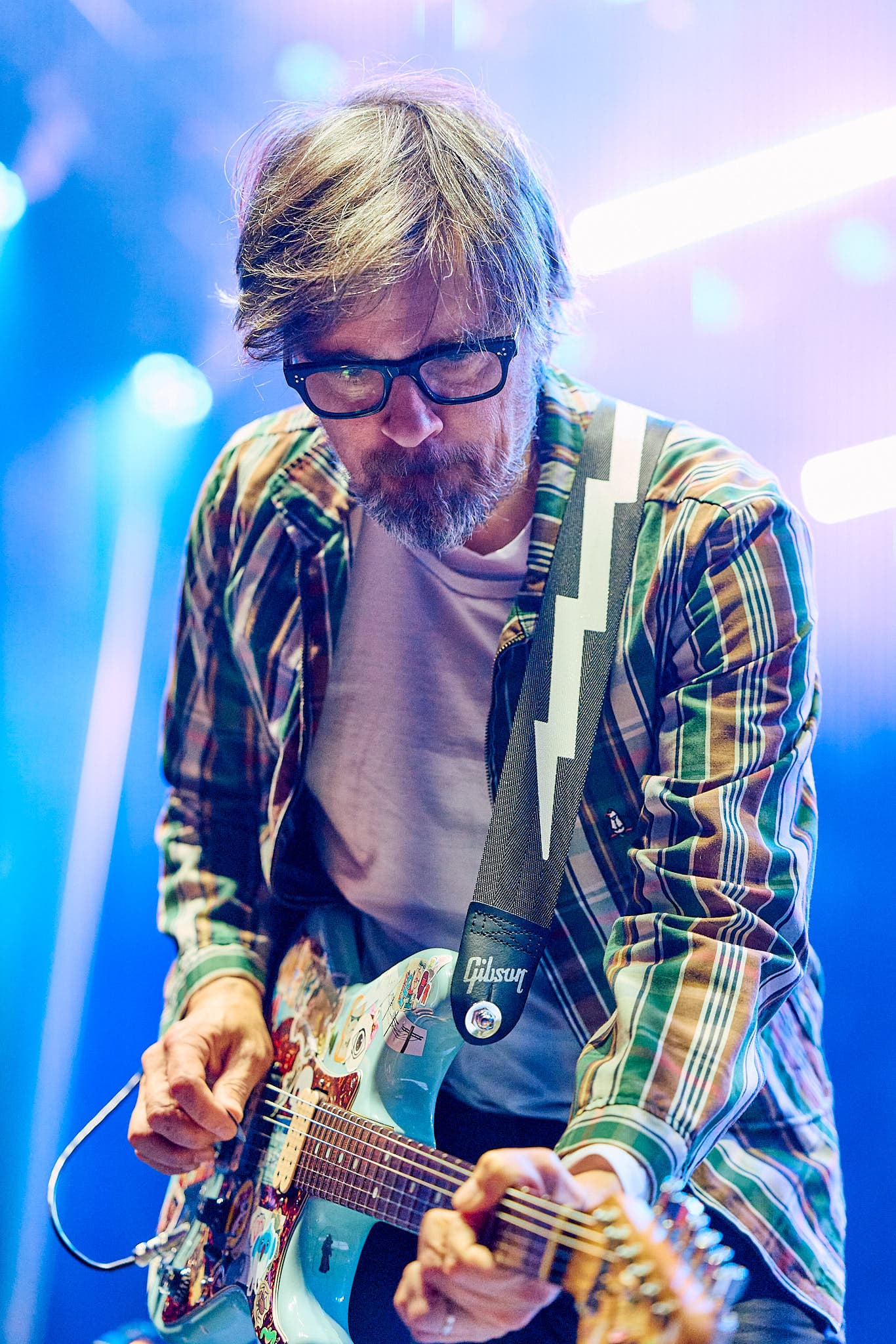 Festival concert photography of Weezer frontman Rivers Cuomo performing at Bumbershoot Arts and Music Festival. Alternative rock band performance with professional stage documentation and festival lighting expertise.