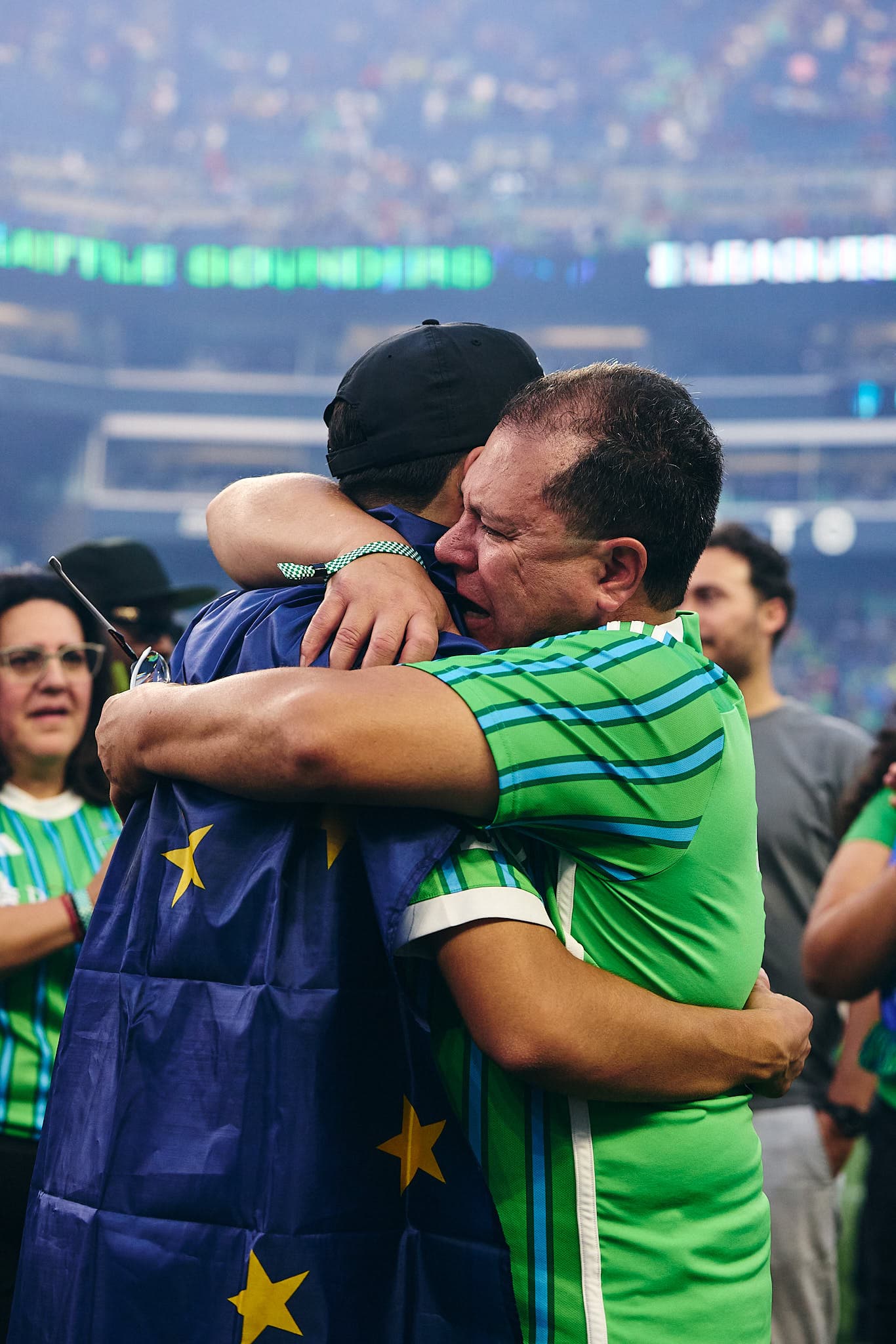 Obed Vargas of Seattle Sounders FC celebrates at the end of the Leagues Cup Final, embracing his father while wrapped in a flag.