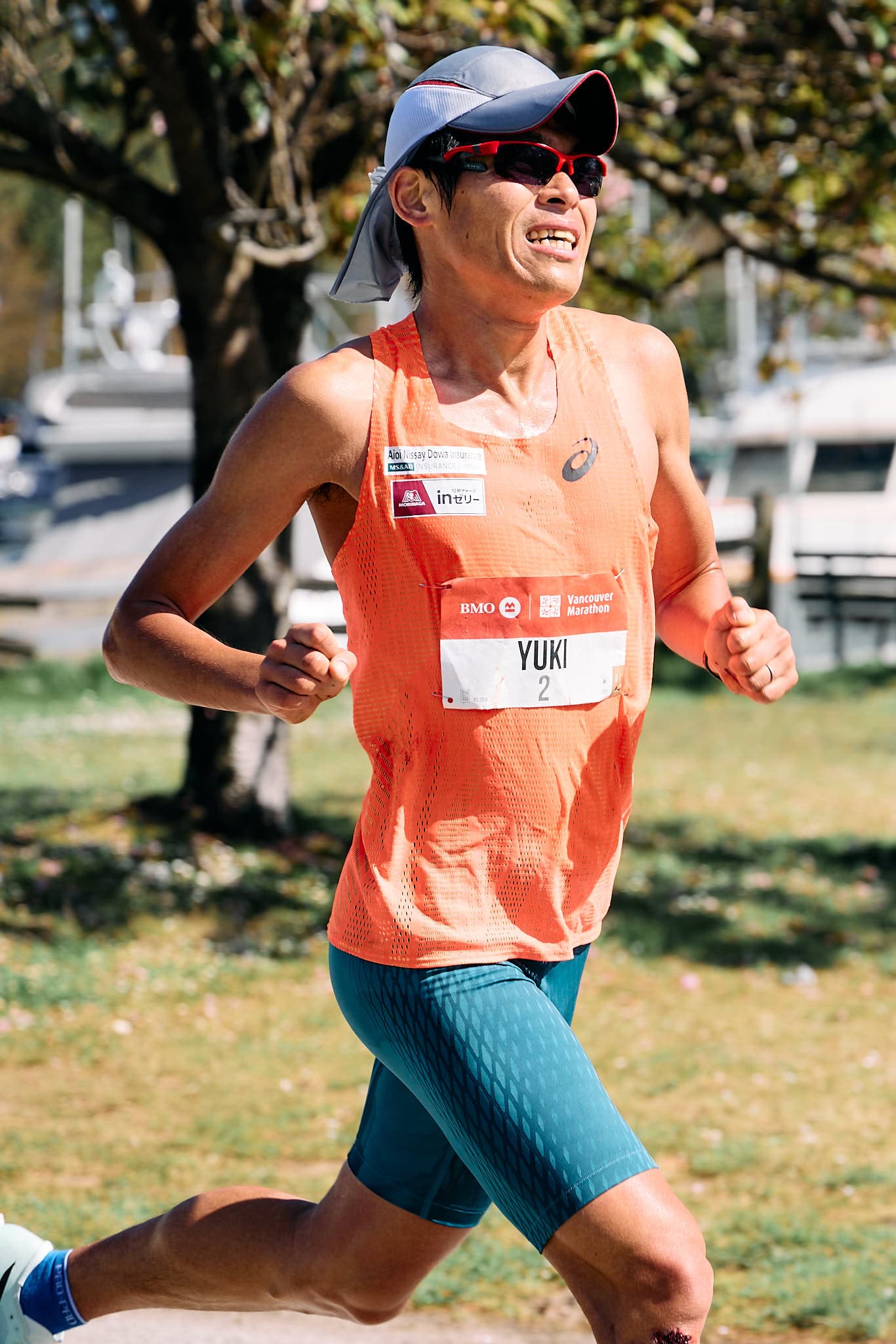 2018 Boston Marathon champion Yuki Kawauchi of Japan strides through the final two kilometers of the Vancouver Marathon on May 5, 2025, in Vancouver, Canada. Wearing an orange singlet, cerulean half tights, and sky blue ASICS running super shoes with white accents, his powerful form and determined expression highlight endurance and athletic excellence in this dynamic sports event photography moment.